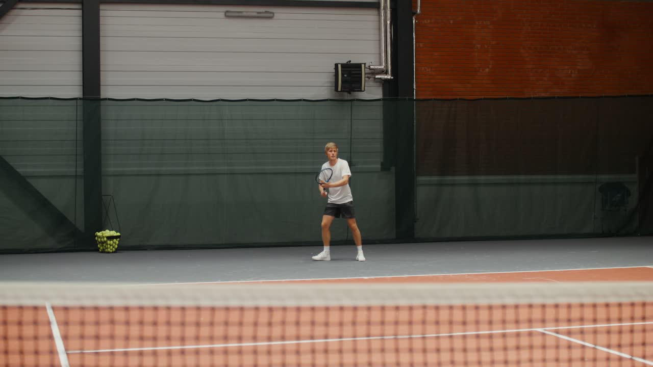 실내에서 테니스를 하는 남자