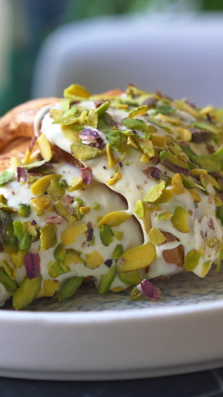 Close-up of a Croissant with White Glaze and Pistachio Topping
