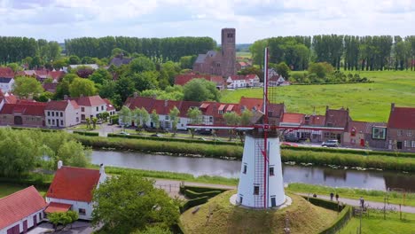 aerial over canal and small town of damme belgium and historic windmill 2