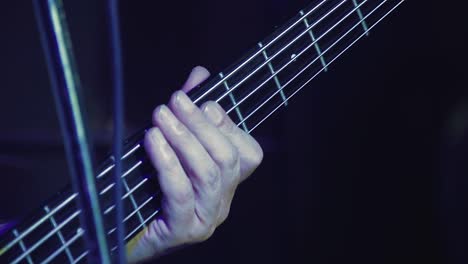 closeup guitarist hand smashes strings