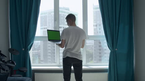 young man working from home at window