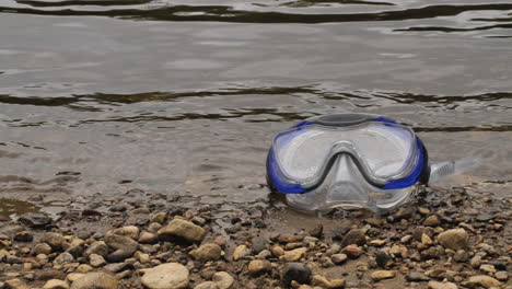 gafas en una playa de guijarros en cámara lenta