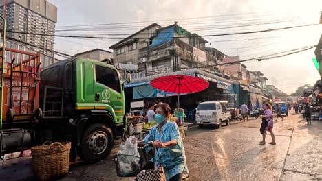 busy market street with pedestrians and a green truck