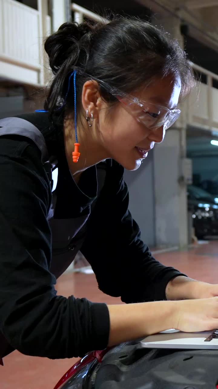 Woman Mechanic Using Laptop in Auto Repair Shop