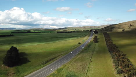 Drone-Pan-Down-With-Cars-Driving-Along-Highway-Lined-With-Trees