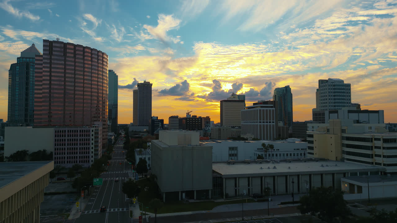Horizonte de Tampa ao nascer do sol com um belíssimo céu azul, amarelo e laranja e luz dourada refletindo nos edifícios, foto aérea do momento do pouso