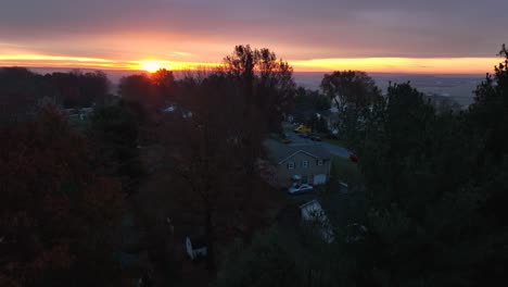 aerial rising shot reveals homes at morning dawn sunrise