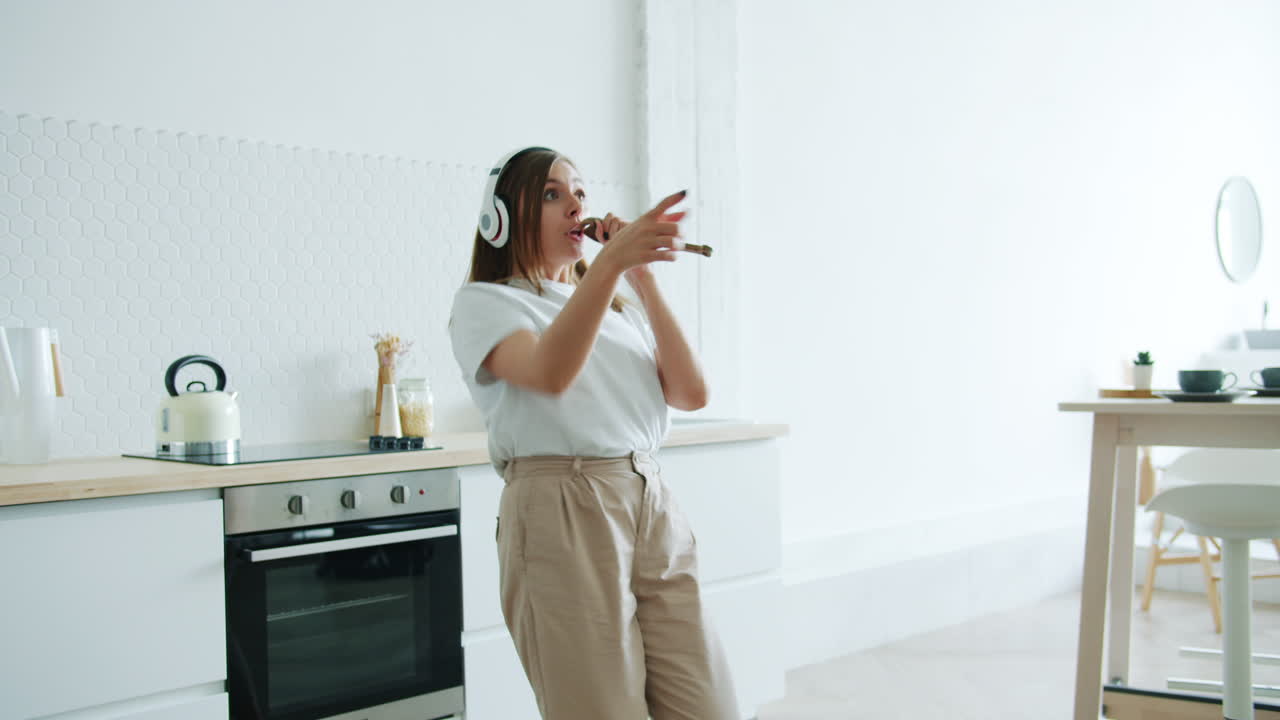 Donna che canta e balla in cucina