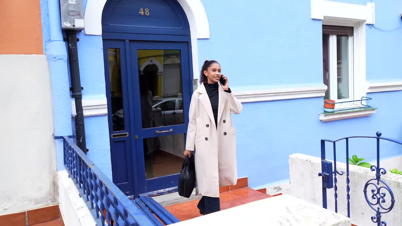 Woman walking and talking on the phone on a city street