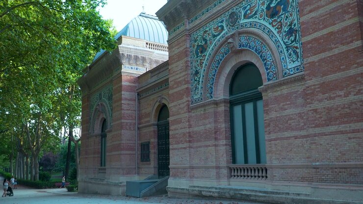 Madrid, Retiro Parkı'nda yer alan, karmaşık seramik çini işçiliği ve tuğla mimarisine sahip tarihi Velazquez Sarayı'nın dış cephesi. Otantik seyahat ve miras konsepti.