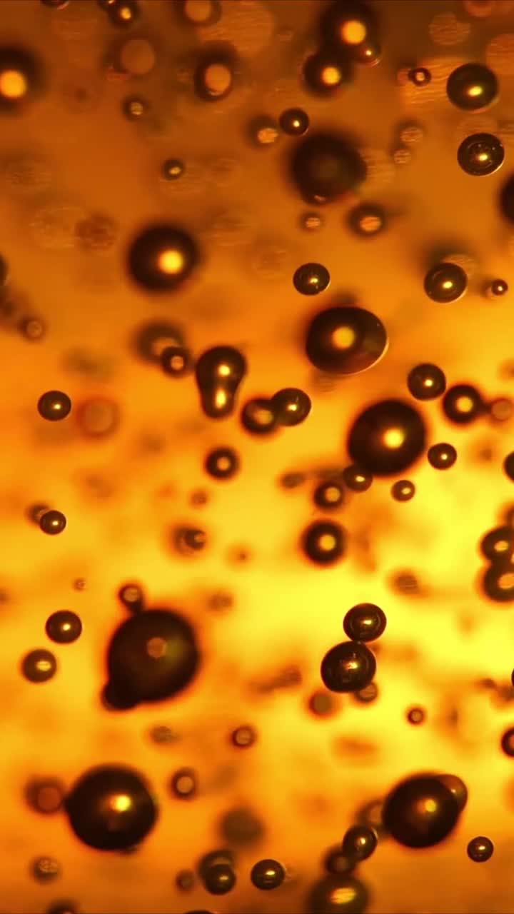 Primer plano de burbujas doradas ascendiendo en líquido abstracto