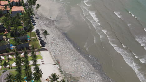 Aerial-top-down-shot-of-polluted-beach-in-front-of-luxury-resort-with-palm-trees-in-Thailand