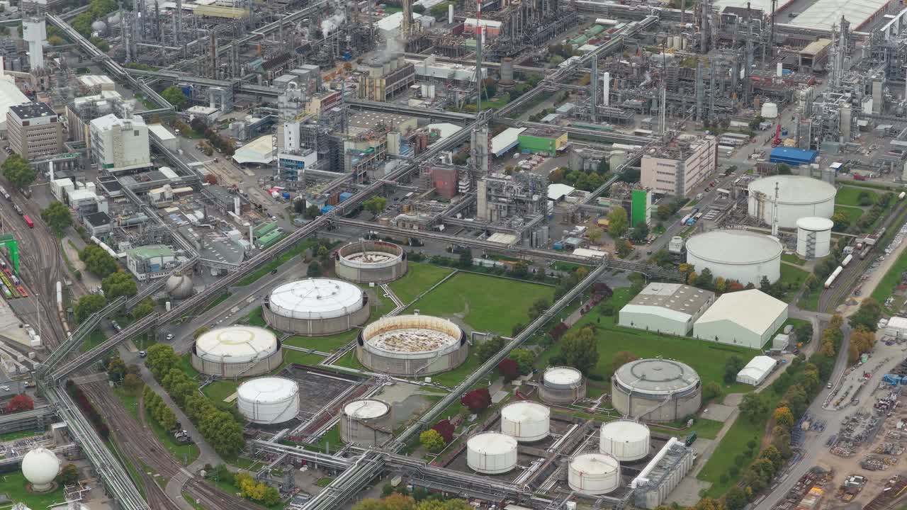 Expansive aerial view of a sprawling oil refinery and petrochemical complex with tanks, pipelines and distillation towers illustrating large scale fuel production and industrial infrastructure