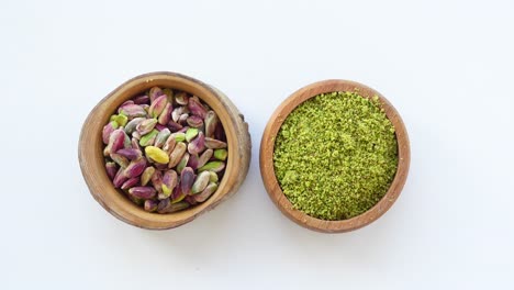 pistachios and grounded pistachios in wooden bowls