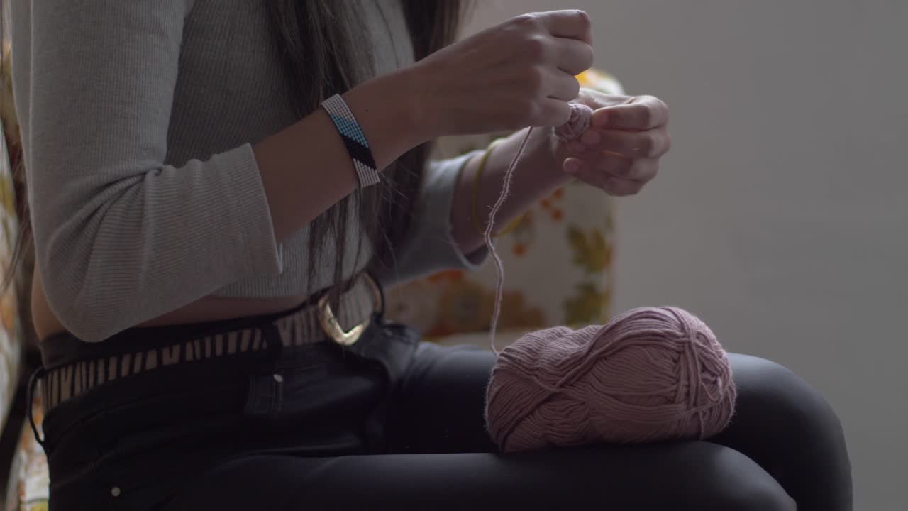 여자 는 더 큰 스풀 에서 작은 공 으로 가닥 을 감싸고, 중간 측면 으로 보기