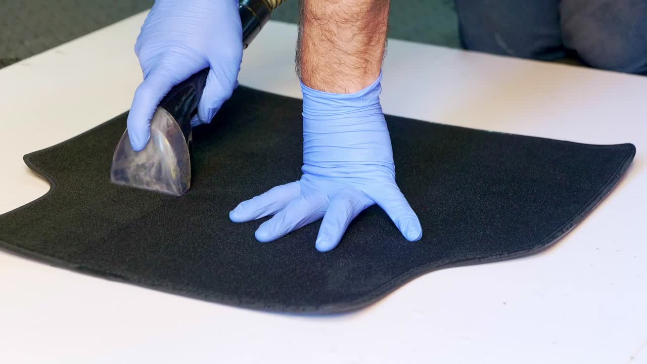 Extracting water from a small carpet car foot with a wet vac vacuum - close up