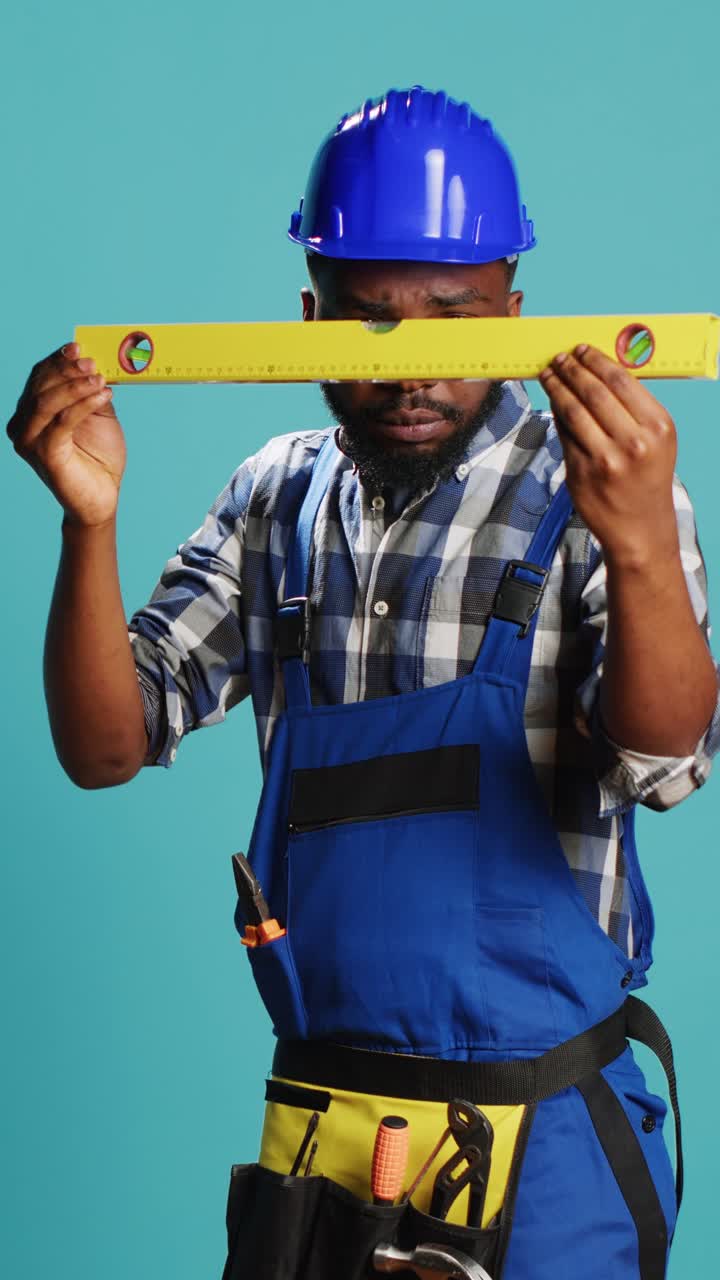 Vertical video: Young adult measuring surface with bench level tool