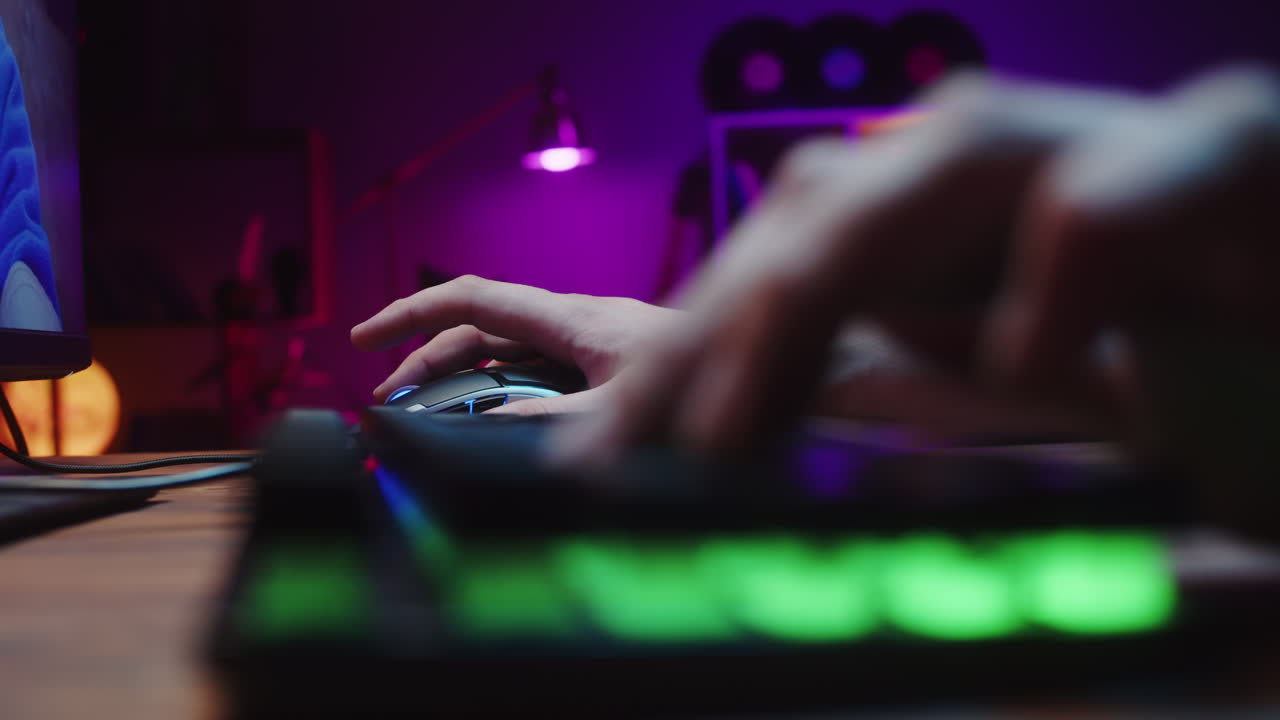 Close-up of Hands Typing on Backlit Keyboard and Using Mouse