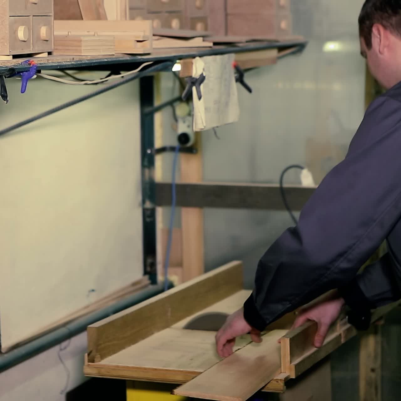 hombre usa una sierra eléctrica para cortar tablas de madera