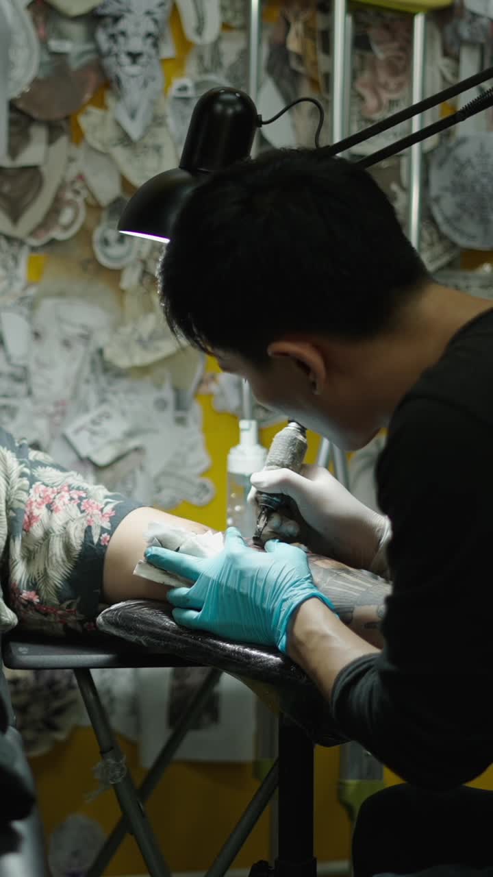 Tatuatore al lavoro su un tatuaggio