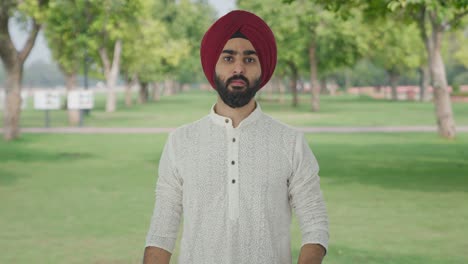 hombre indio sikh enojado desafiando a alguien a pelear en el parque