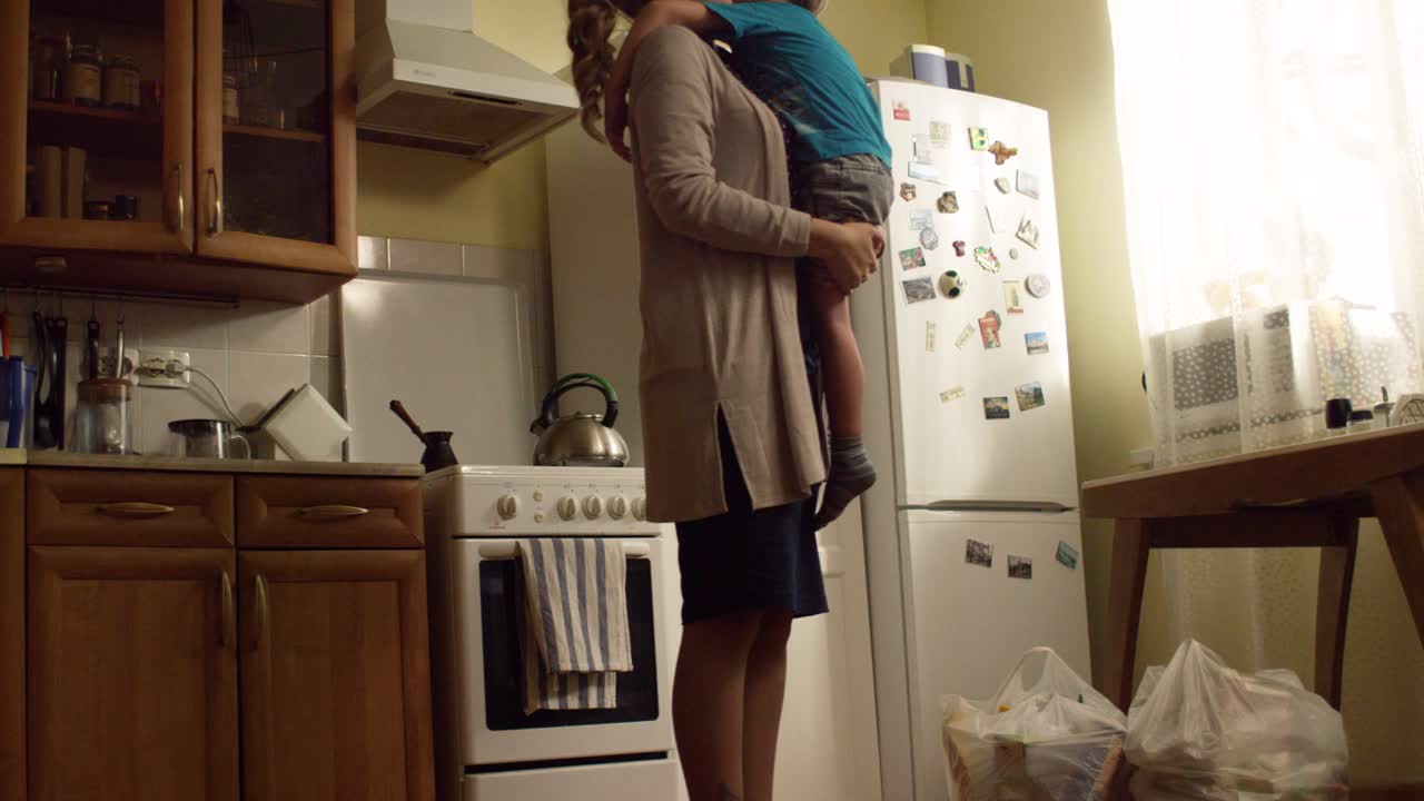 Mãe Carregando Criança na Cozinha
