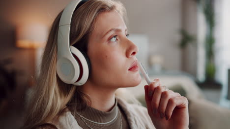 young blonde woman wearing headphones and thinking