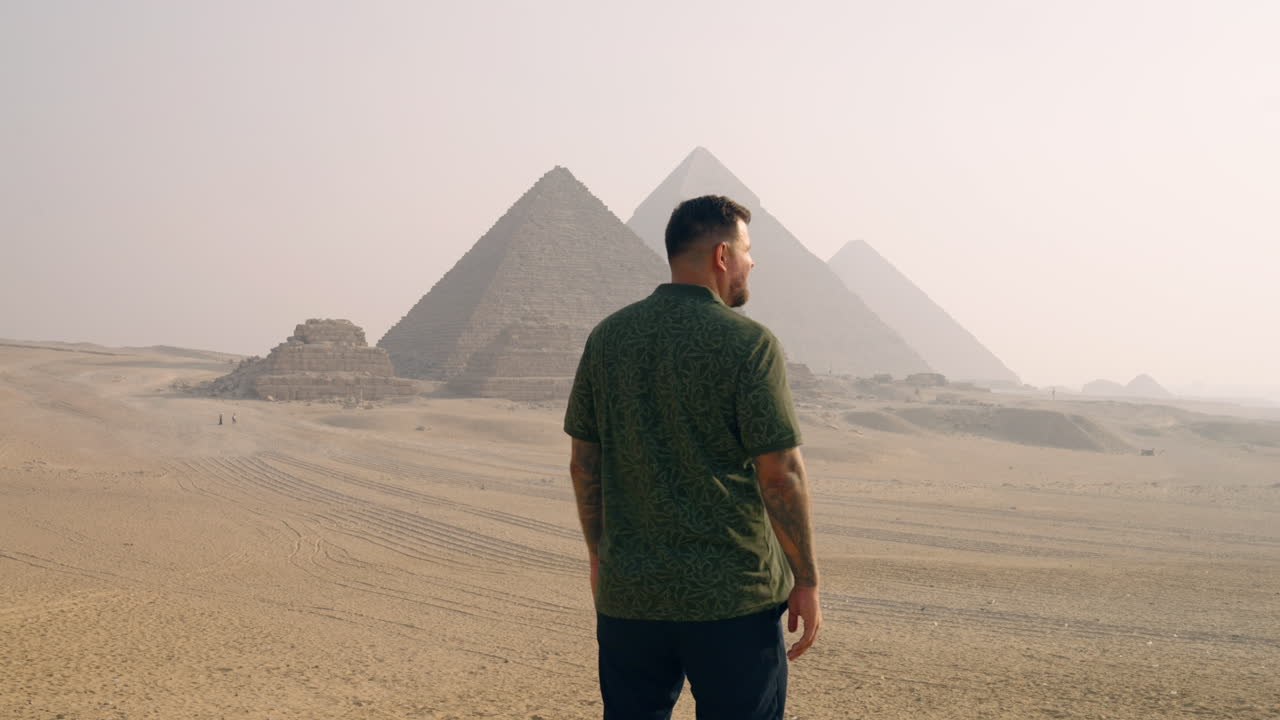 A Man Admiring the Giza Plateau, With the Pyramids in View at Sunrise Near Cairo, Egypt - Static Shot