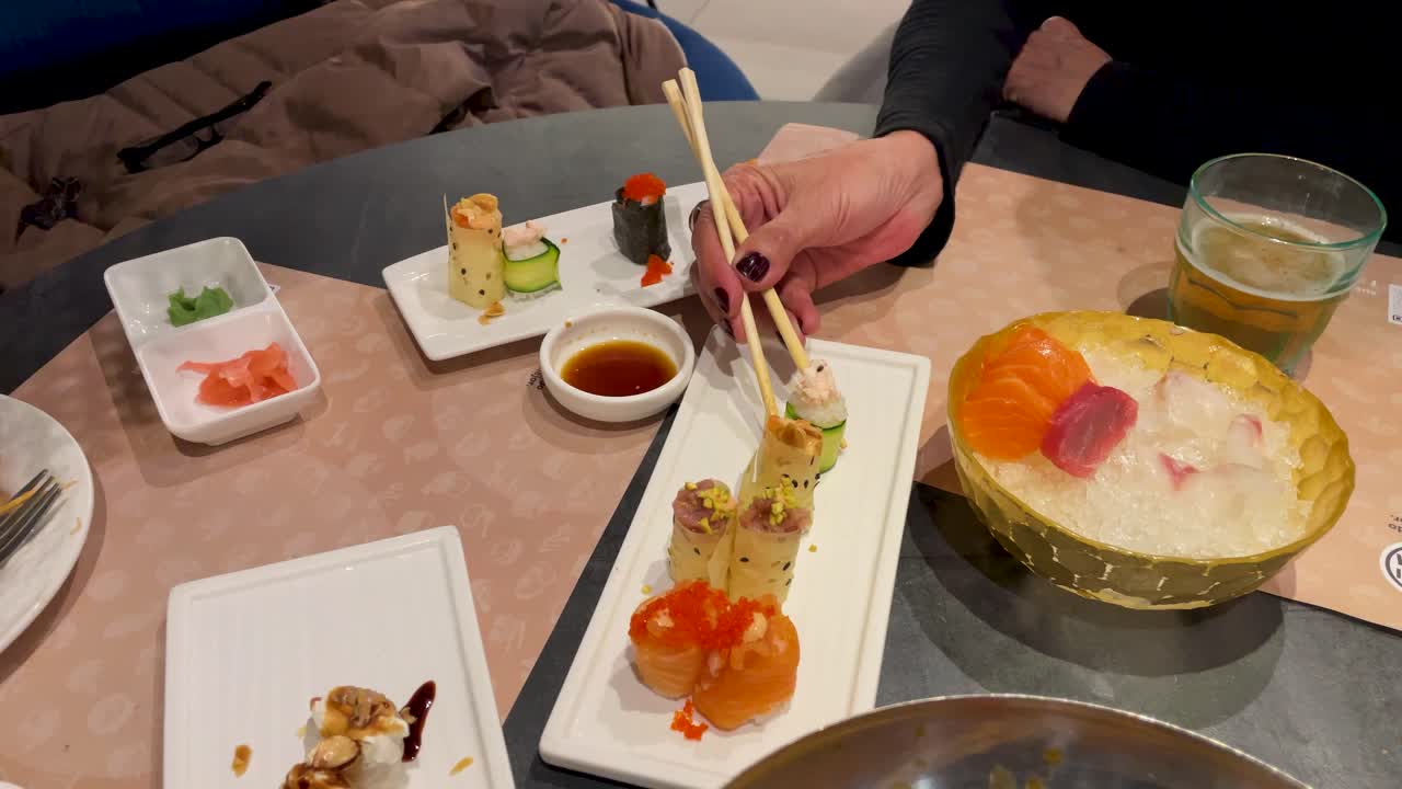 우리는 가락을 들고 수시를 들고 콩 소스에 는 여성의 손을 볼 수 있습니다.