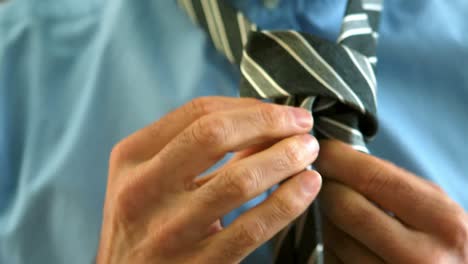 businessman tying his tie