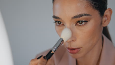 closeup lady powdering face using brush home. woman applying foundation makeup