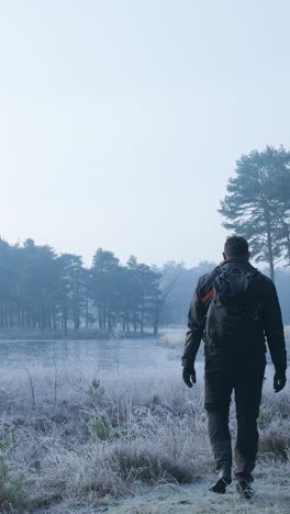 man hiking in a frozen winter forest