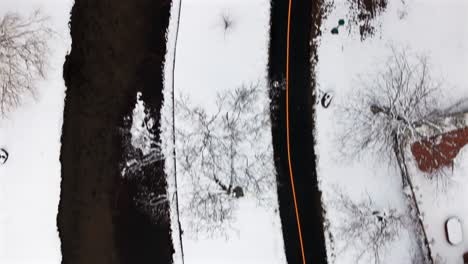 Una-Vista-Aérea-De-Arriba-Hacia-Abajo-De-Un-Parque-Cubierto-De-Nieve-En-Un-Día-De-Invierno