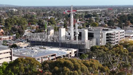 Toma-De-Drone-De-Un-Sitio-De-Construcción-Con-Una-Grúa-Blanca.