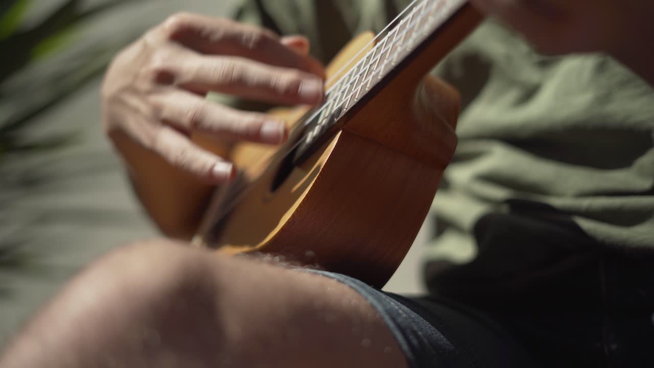 primer plano de un hombre tocando el ukelele afuera