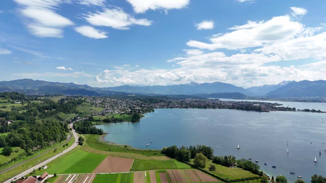 panorámica aérea de rapperswil y el lago de zurich en un día soleado con exuberante vegetación y cielos despejados