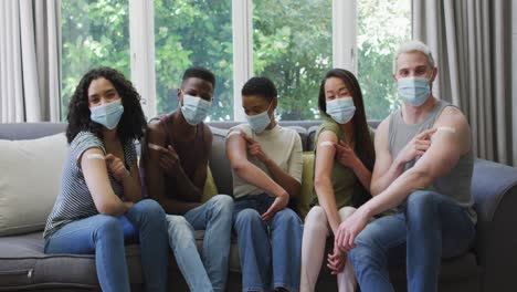 Group-of-diverse-young-people-showing-their-vaccinated-shoulders-at-home