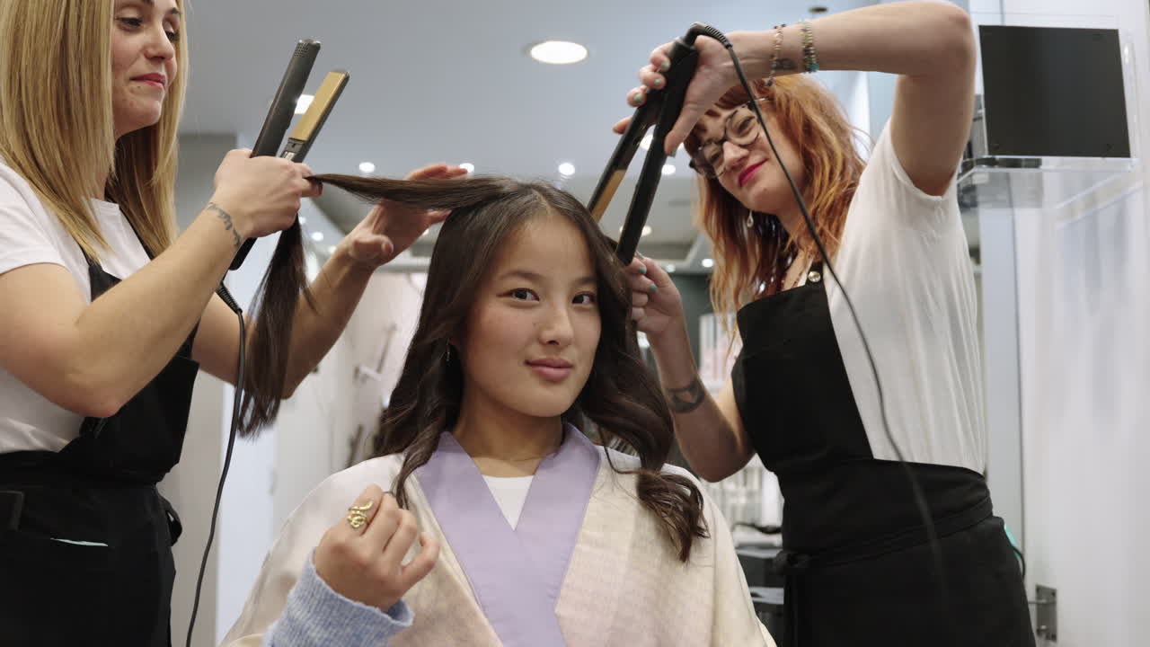 Woman getting her hair straightened at a salon