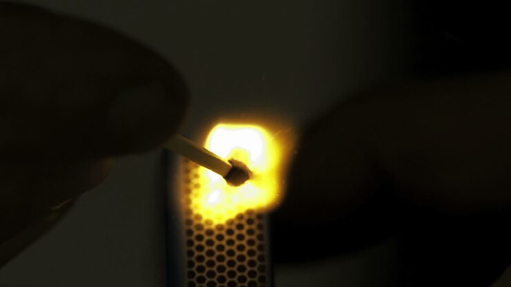 Match lighted against a black background