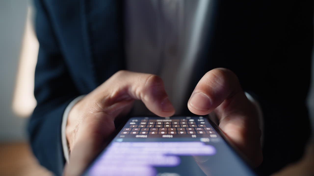 Dettaglio macro di mani maschili che chattano online su smartphone. Utente che digita un messaggio di testo