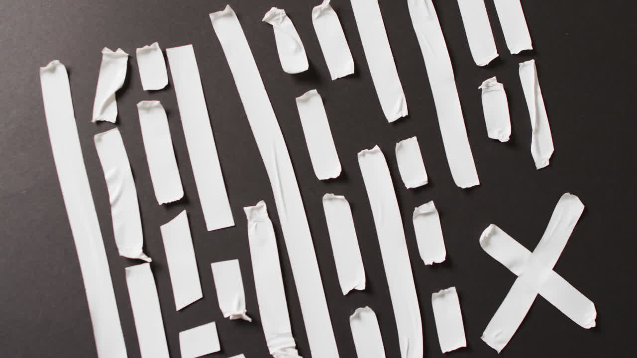 video de primer plano de múltiples piezas de cintas blancas sobre fondo negro