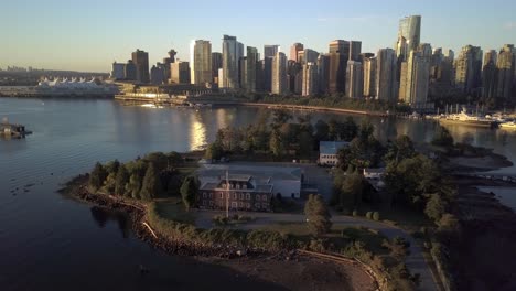 Vancouver-Downtown-Skyline,-Coal-Harbour-And-HMCS-Discovery-Canadian-Navy-Reserve-on-Deadman's-Island-Seen-From-Brockton-Point-At-Stanley-Park-On-A-Sunrise