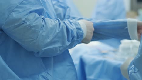 the surgeon prepares for the operation, fastens the sterile gown in the modern operating room.