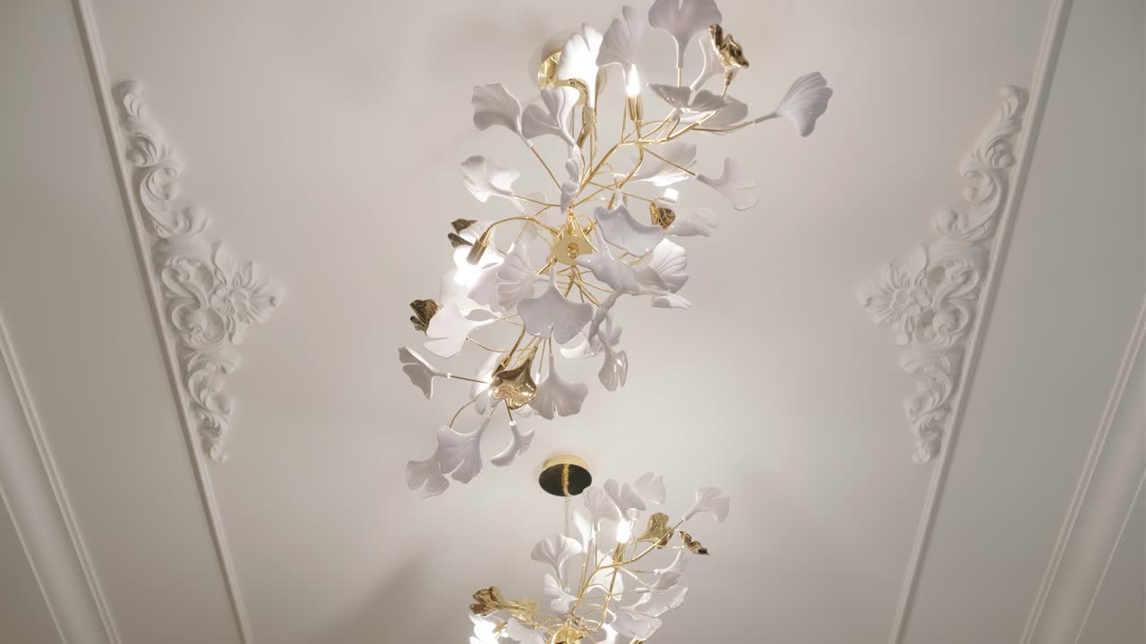 클래식 모딩으로 장식 된 천장에 맞춰 꽃 요소와 함께 복잡한 색과 금색 천장 조명