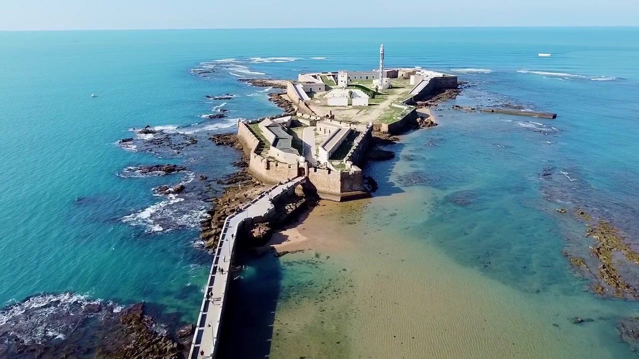 Cadice. Spagna. Veduta aerea del Castello di Santa Catalina. Spiaggia La Caleta. Veduta di una fortificazione militare del XVII secolo accanto a un mare dai colori vivaci e onde che si infrangono contro le rocce.