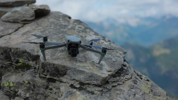 Primo piano del drone DJI Air 3 su una roccia con le montagne della Valmalenco sullo sfondo, Italia
