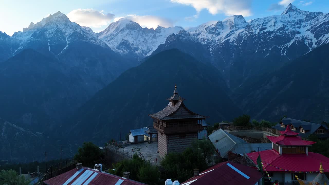 una toma aérea del pueblo de kalpa, rodeado de huertos de manzanas y respaldado por kinner kailash.