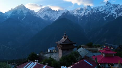 una toma aérea del pueblo de kalpa, rodeado de huertos de manzanas y respaldado por kinner kailash.