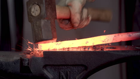 hammering red hot metal on an anvil