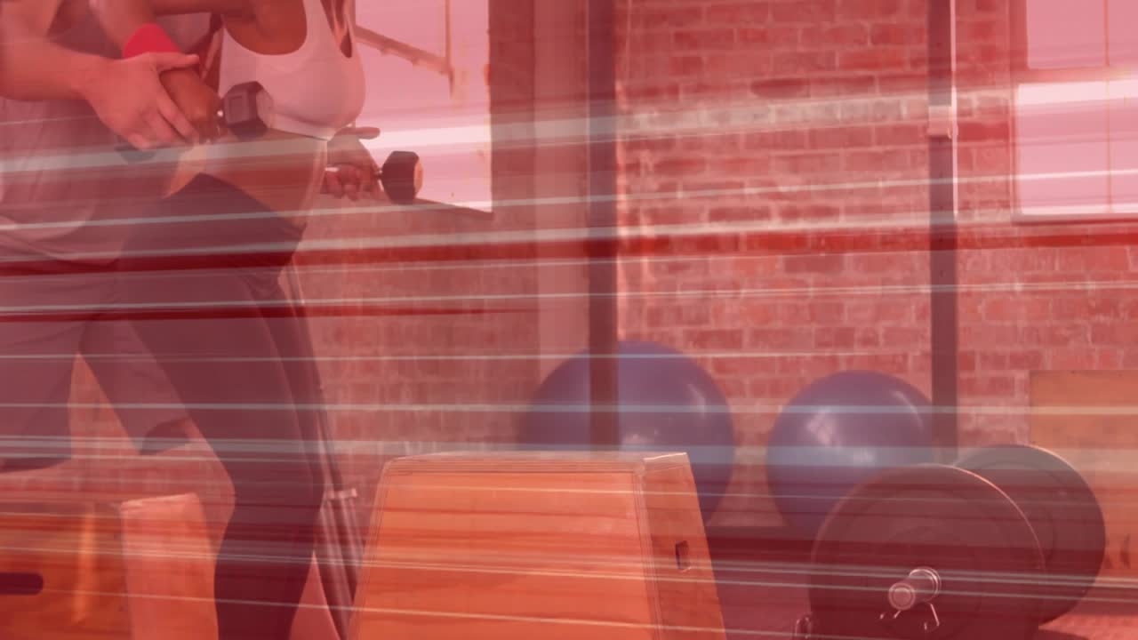 Instructor placing hands, guiding client pulling weights for form in gym, red streaks crossing